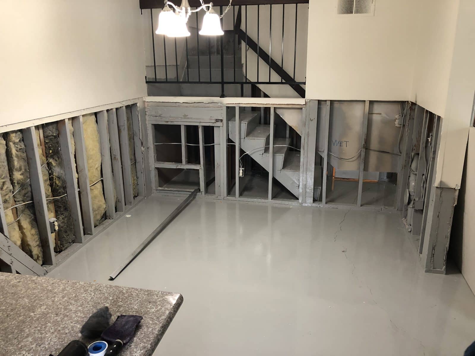 Room opened to the studs with the concrete slab and lower framing sealed in gray Odor Encapsulator
